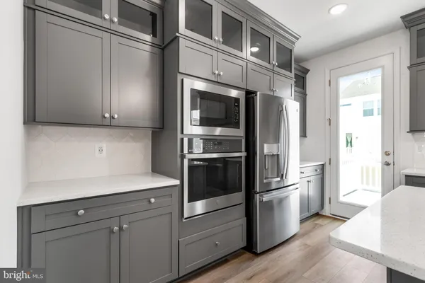 a kitchen with stainless steel appliances white cabinets and a refrigerator