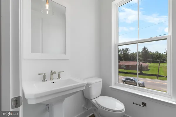 a bathroom with a sink a toilet and a mirror