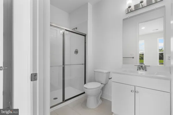 a bathroom with a toilet sink vanity and mirror