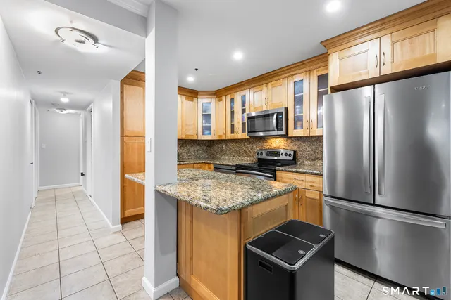 a kitchen with stainless steel appliances granite countertop a stove a sink and a microwave