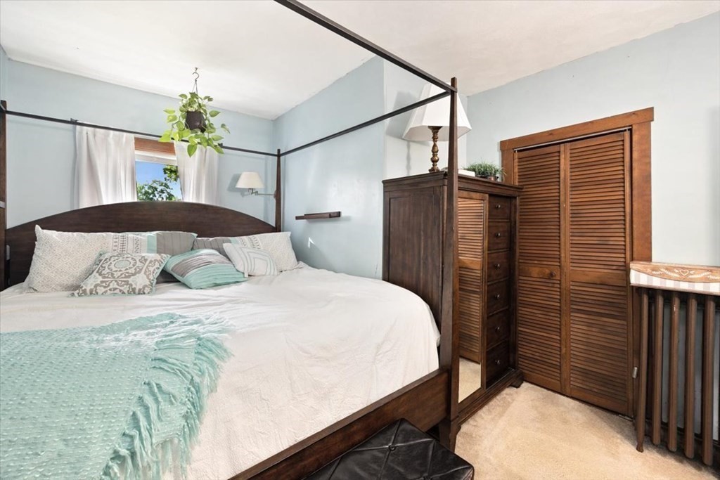 89-91 East Street Mansfield, MA 02048 - Photo 12 of 38 a bedroom with a bed and a chandelier