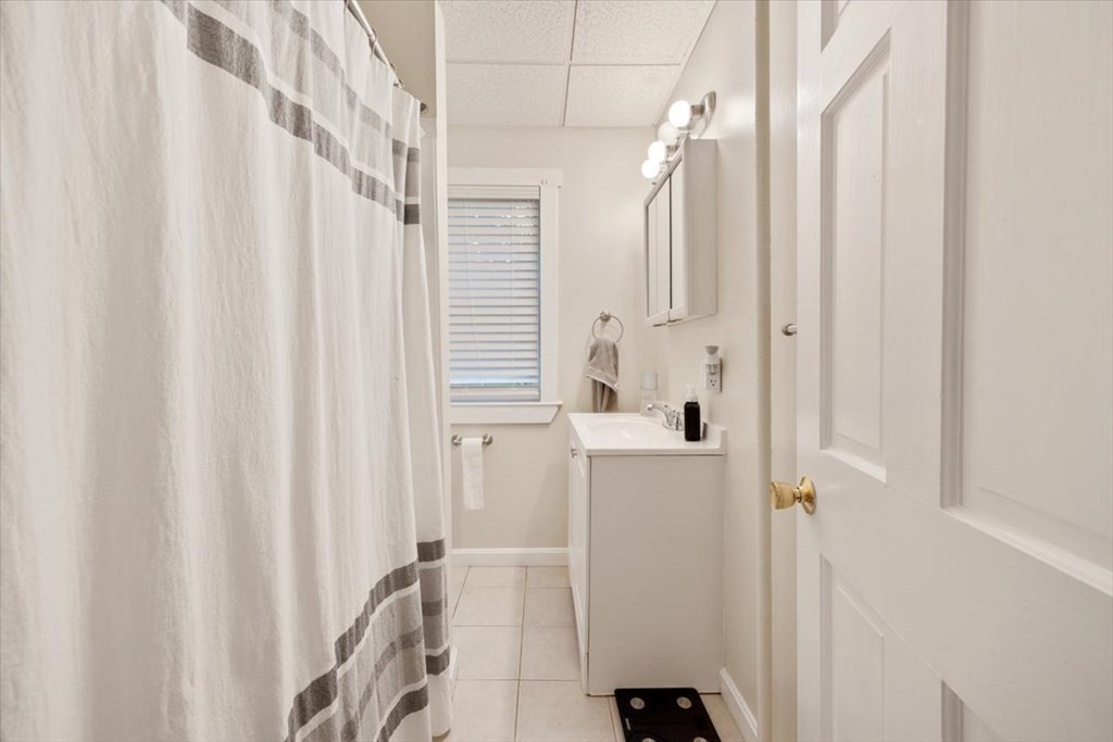 89-91 East Street Mansfield, MA 02048 - Photo 19 of 38 a bathroom with a shower curtain and a window