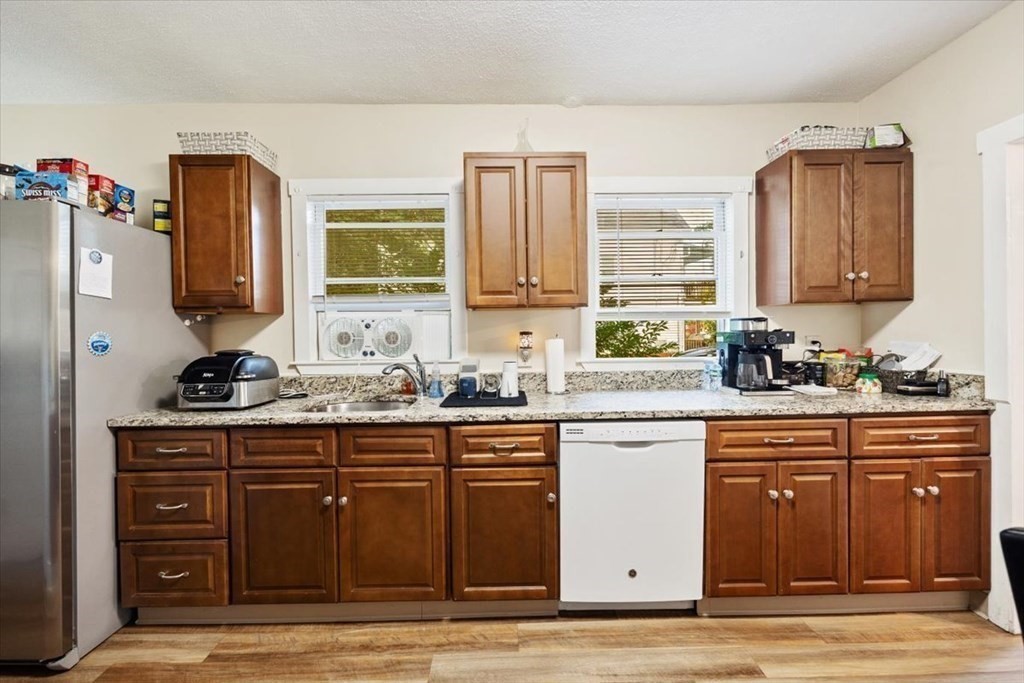 89-91 East Street Mansfield, MA 02048 - Photo 3 of 38 a kitchen with granite countertop a sink cabinets and wooden floor