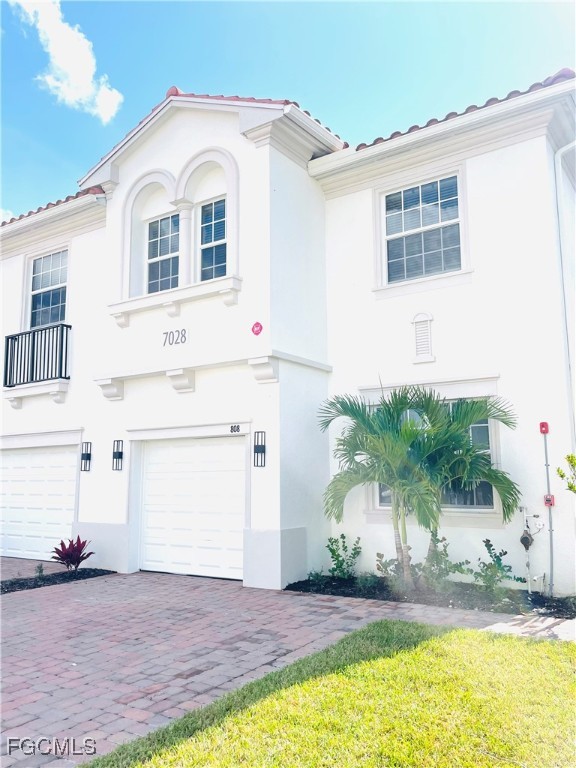 7028 Ambrosia Lane, Unit 808 Naples, FL 34119 - Photo 1 of 8 a view of a white house with a yard and plants