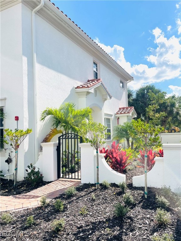 7028 Ambrosia Lane, Unit 808 Naples, FL 34119 - Photo 2 of 8 a front view of a house with a yard
