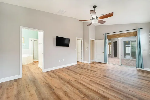 a view of a livingroom with wooden floor and a ceiling fan