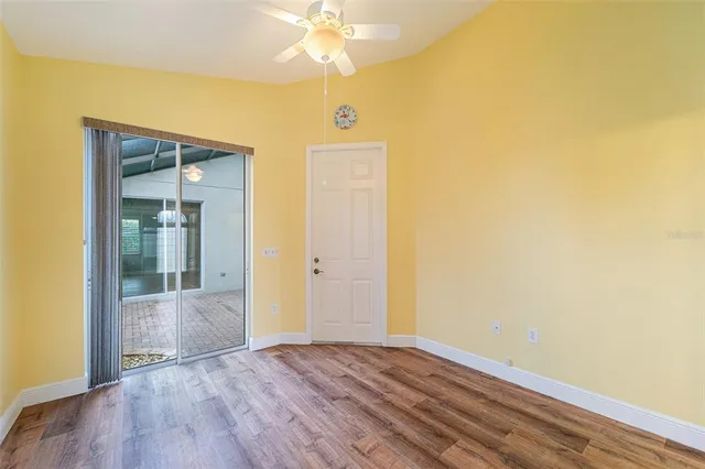 a view of a hallway with wooden floor and a bathroom