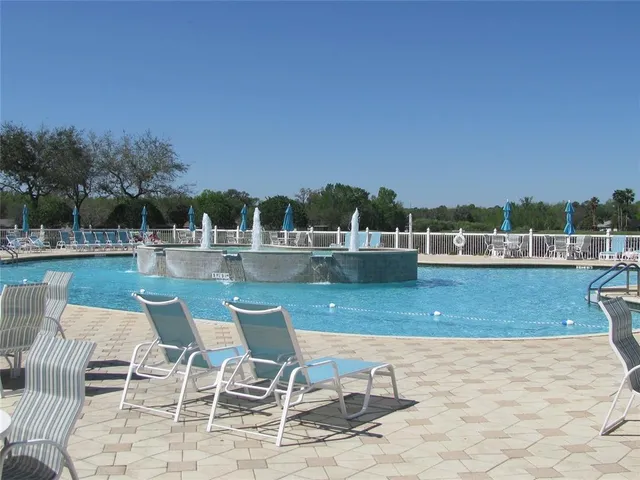 a sign that is sitting in the grass near a tree