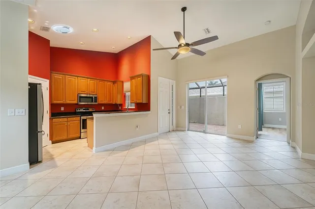 a view of a kitchen with kitchen island granite countertop a refrigerator and a stove top oven