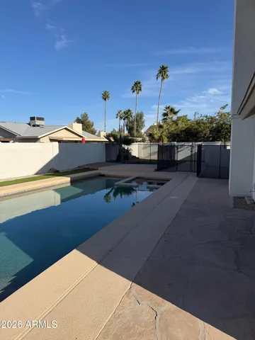 a view of swimming pool with seating area and lake view