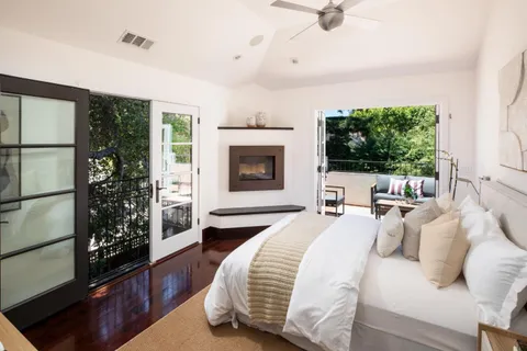 a living room with furniture a fireplace and a floor to ceiling window