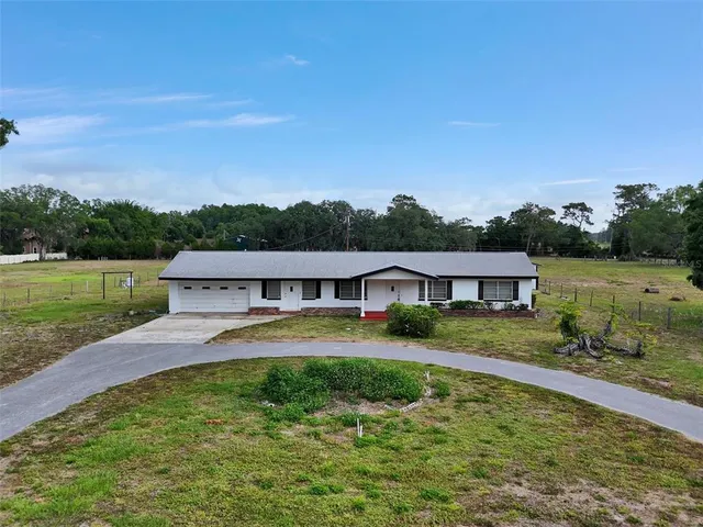 a view of a house with pool and a yard