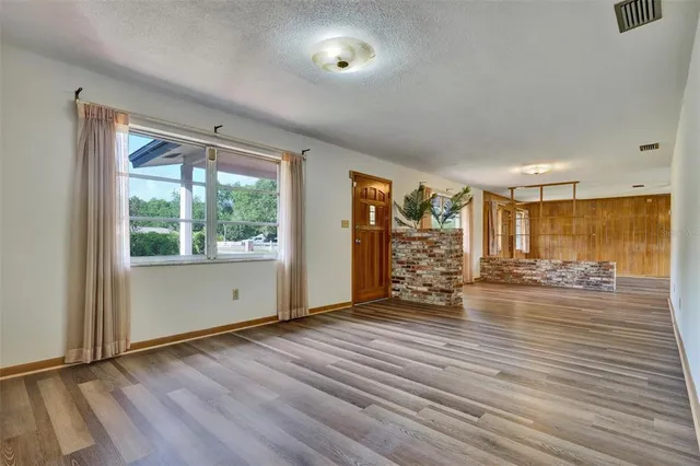 a view of a room with wooden floor and a window