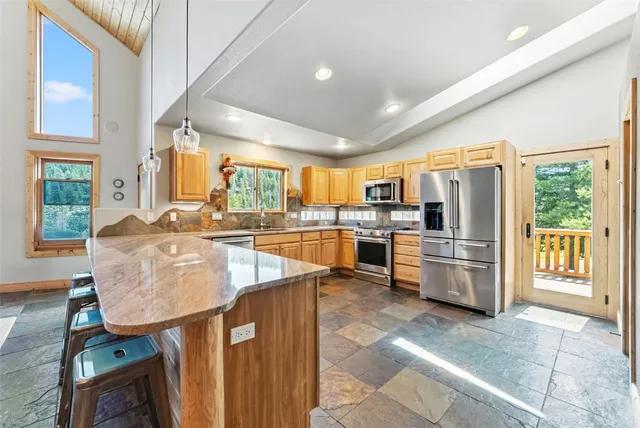 a large kitchen with kitchen island granite countertop a large counter top stainless steel appliances and cabinets
