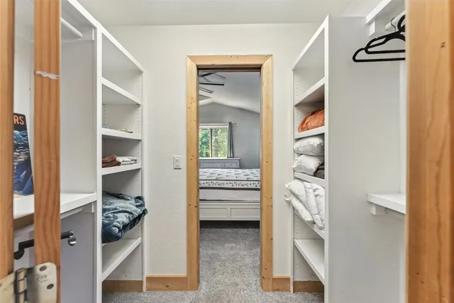 a view of walk in closet with clothes and shoes