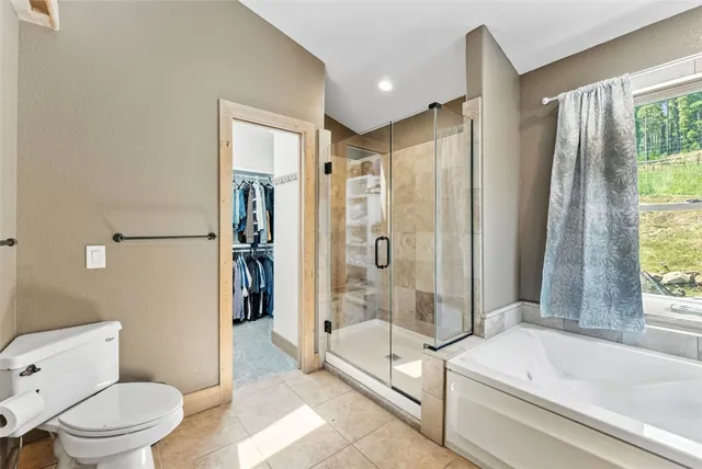 a bathroom with a tub shower and toilet