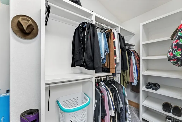 a view of walk in closet with clothes and shoes