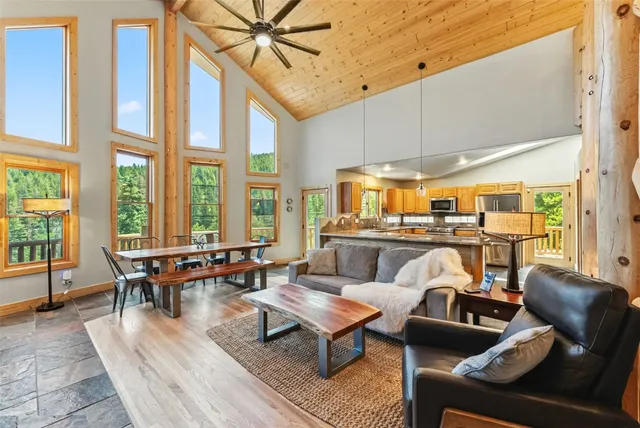a living room with furniture kitchen view and large windows