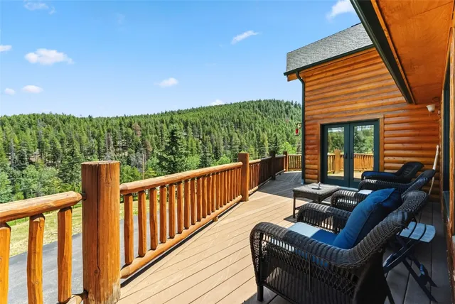 a balcony with wooden floor and outdoor seating