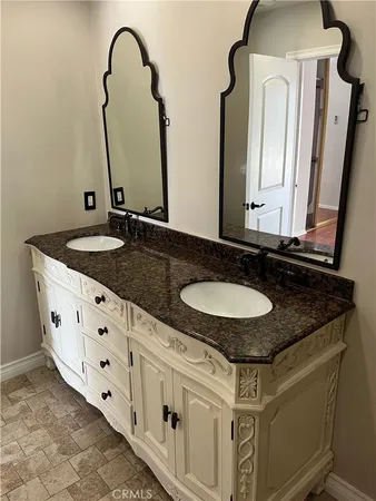 a bathroom with double sink and a mirror