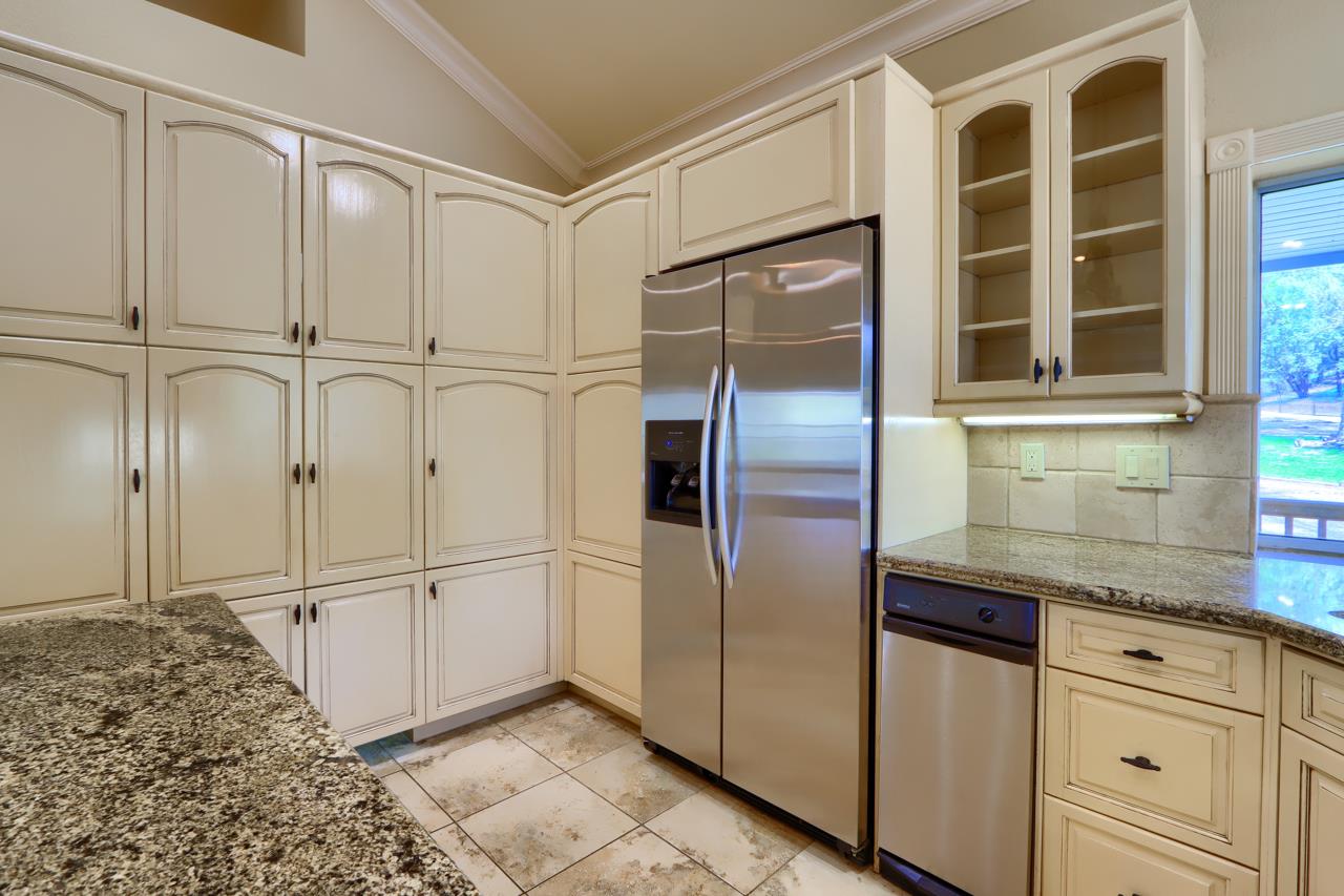 46580 Vista Del Rio Drive Oakhurst, CA 93644 - Photo 19 of 82 a kitchen with granite countertop a refrigerator and white cabinets