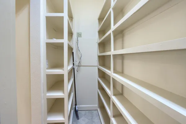 a view of walk in closet with empty racks