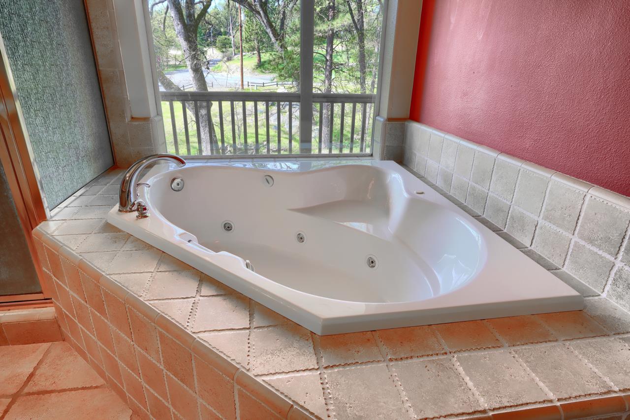 46580 Vista Del Rio Drive Oakhurst, CA 93644 - Photo 34 of 82 a bath tub sitting in a bathroom next to a window