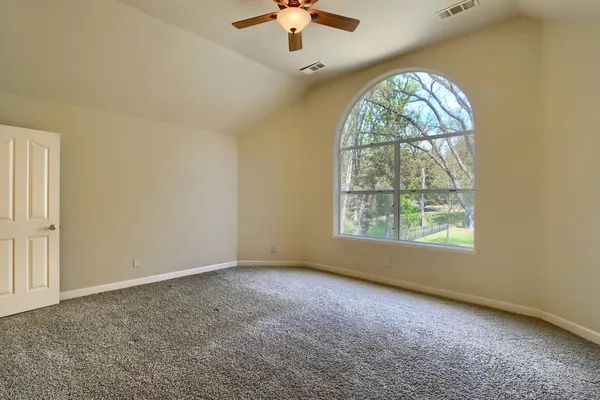 a wooden bench sitting in a yard with large trees