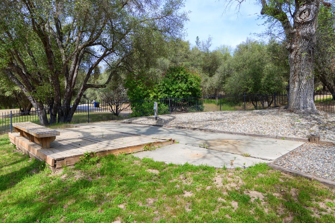46580 Vista Del Rio Drive Oakhurst, CA 93644 - Photo 72 of 82 a wooden bench sitting in a yard with large trees