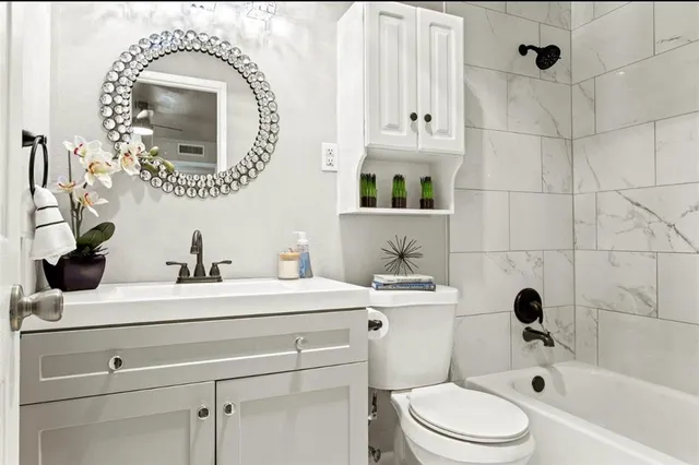 a bathroom with a sink a toilet and shower