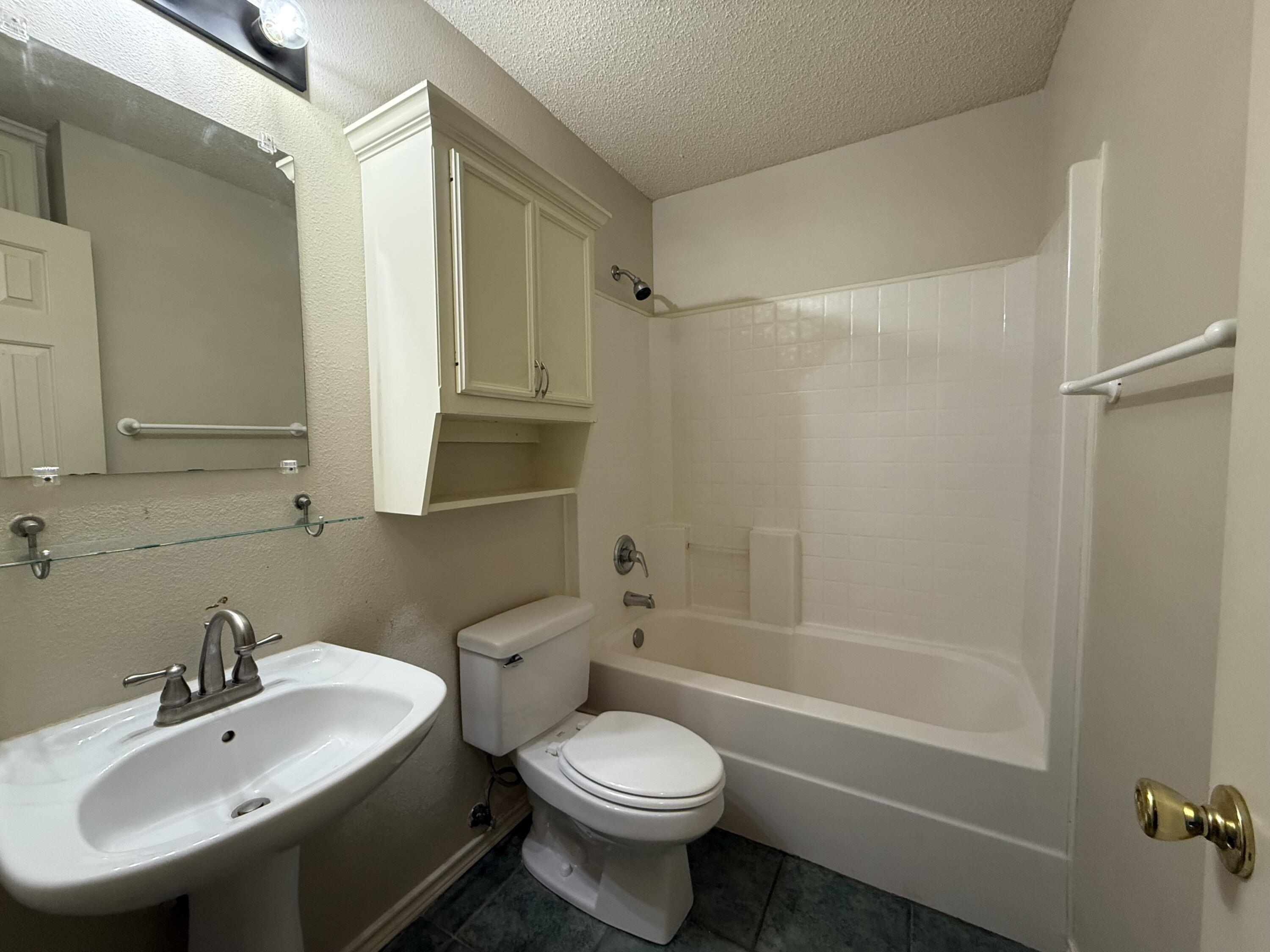 10602 Akron Avenue Lubbock, TX 79423 - Photo 13 of 16 a bathroom with a sink toilet and shower