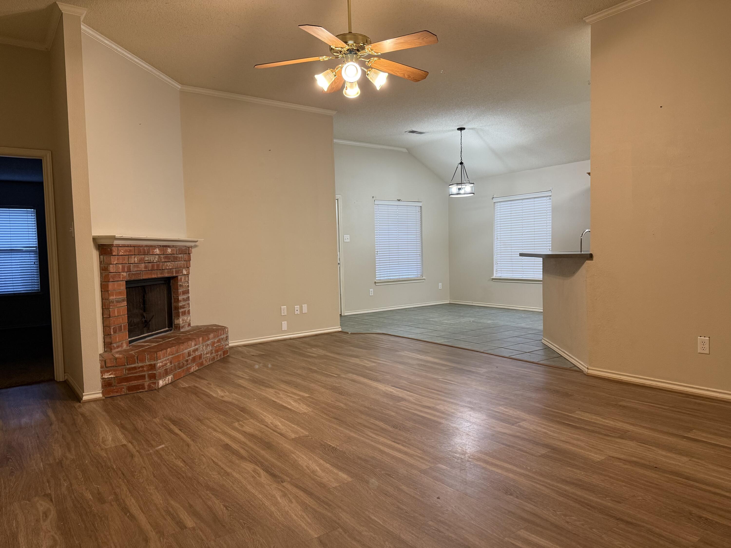 10602 Akron Avenue Lubbock, TX 79423 - Photo 2 of 16 a view of empty room with wooden floor and fan