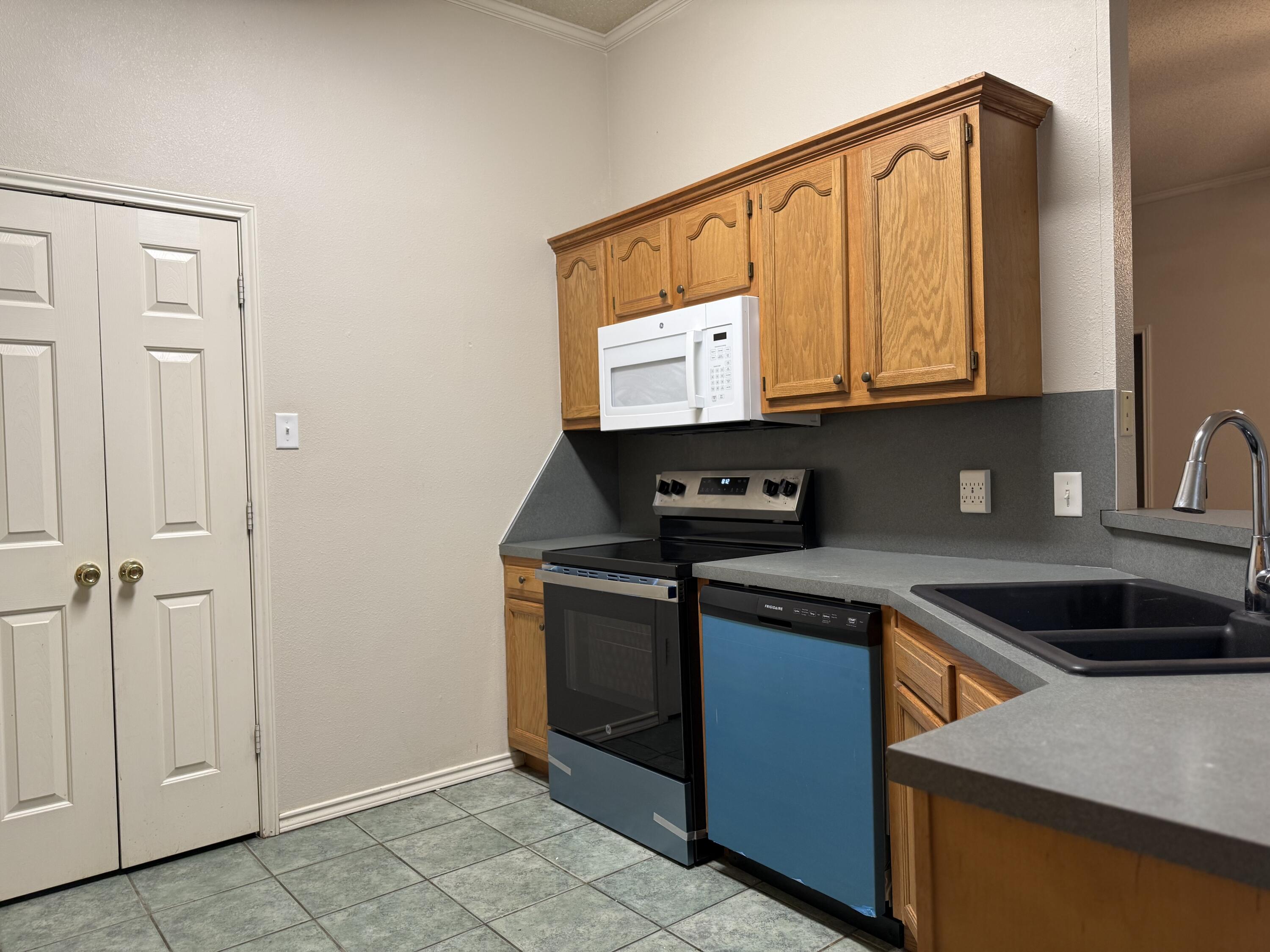 10602 Akron Avenue Lubbock, TX 79423 - Photo 5 of 16 a kitchen with stainless steel appliances granite countertop a stove and a refrigerator