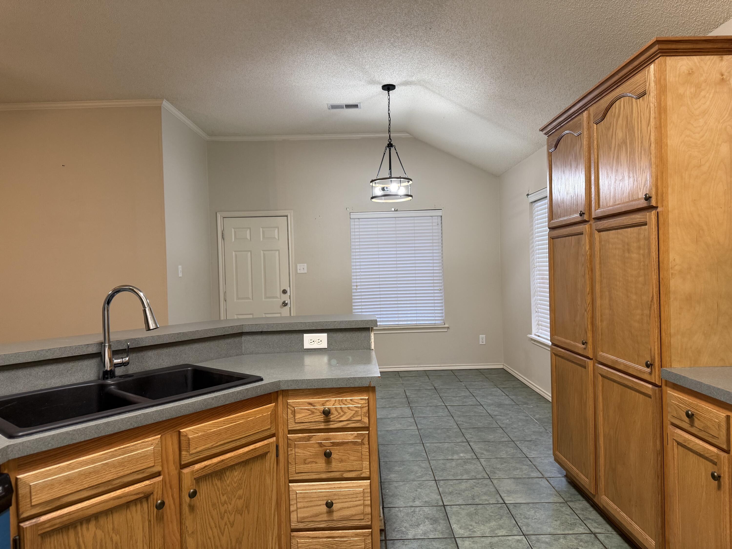 10602 Akron Avenue Lubbock, TX 79423 - Photo 6 of 16 a kitchen with stainless steel appliances granite countertop a sink and a refrigerator