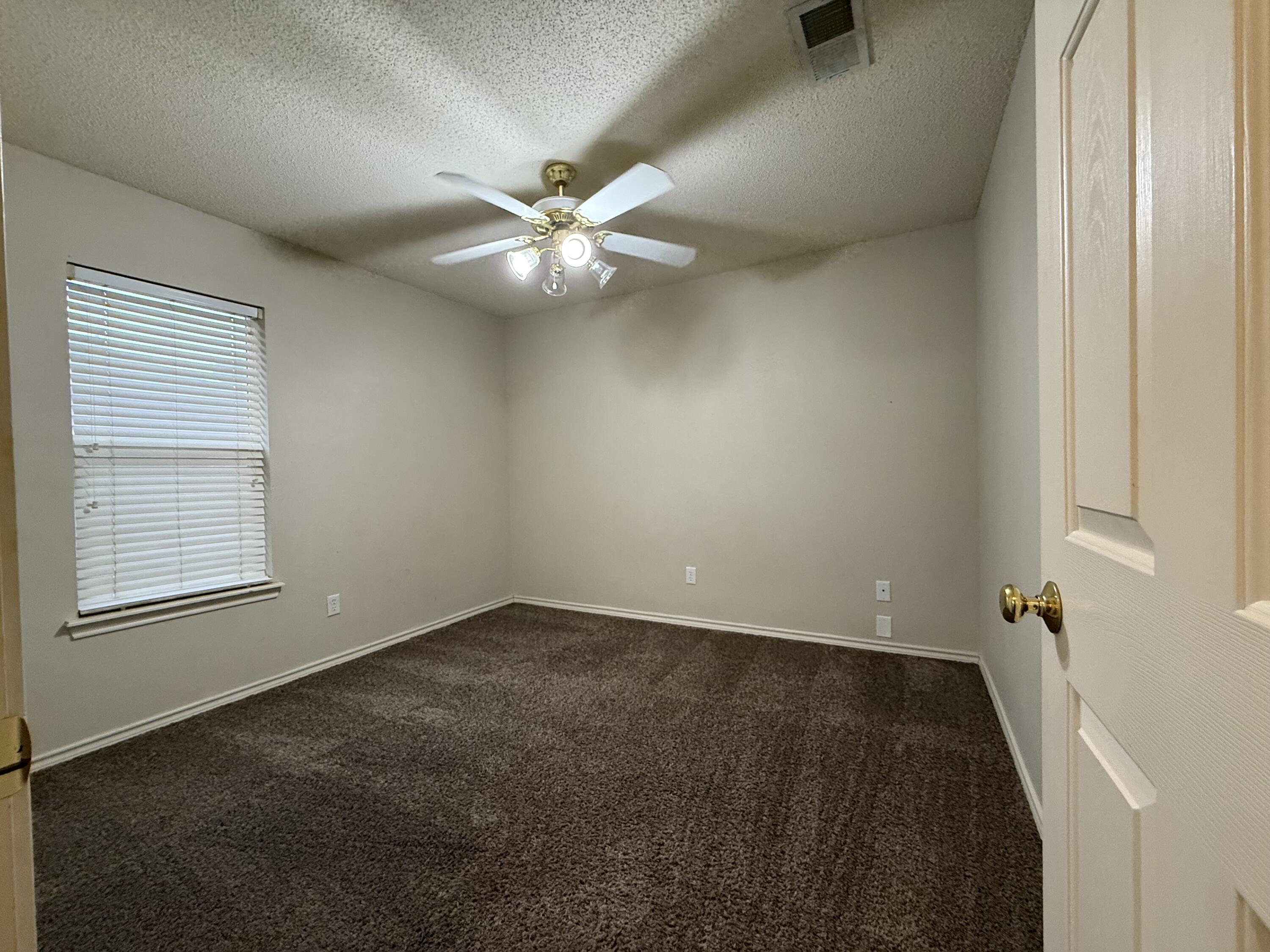 10602 Akron Avenue Lubbock, TX 79423 - Photo 8 of 16 an empty room with a window and a fan