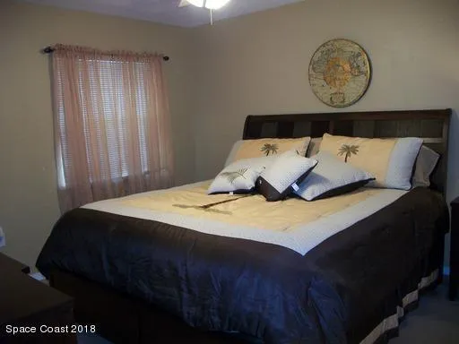 a bed sitting in a bedroom next to a window