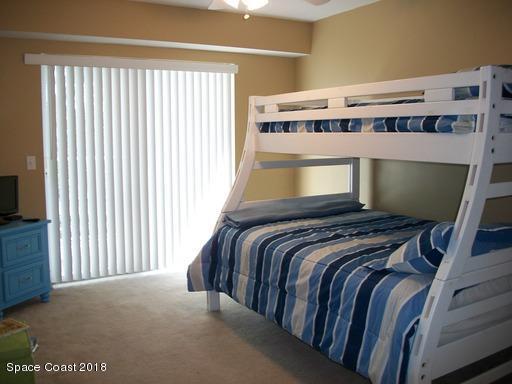 8911 Lake Drive, Unit 206 Cape Canaveral, FL 32920 - Photo 18 of 22 a bed sitting in a bedroom next to a window