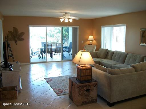 8911 Lake Drive, Unit 206 Cape Canaveral, FL 32920 - Photo 6 of 22 a living room with furniture and a large window
