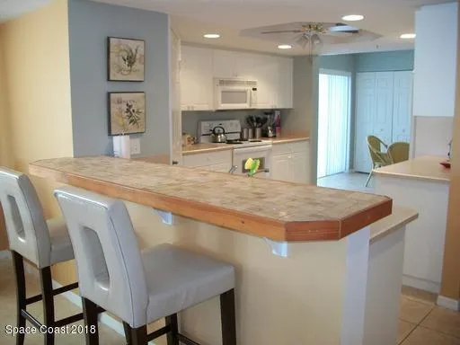 a kitchen with kitchen island a refrigerator and a sink