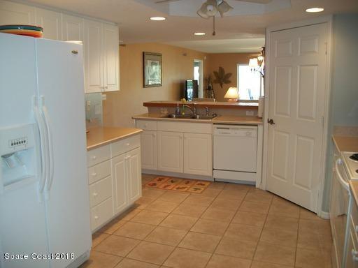 8911 Lake Drive, Unit 206 Cape Canaveral, FL 32920 - Photo 10 of 22 a bathroom with a sink a mirror and a shower
