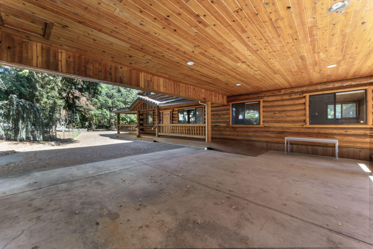 12214 Modoc Road White City, OR 97503 - Photo 13 of 47 a view of a patio with table and chairs under an umbrella with wooden fence