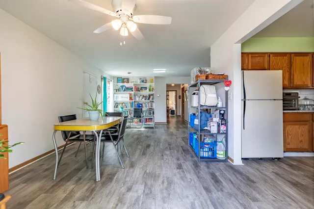 a living room with furniture and a refrigerator