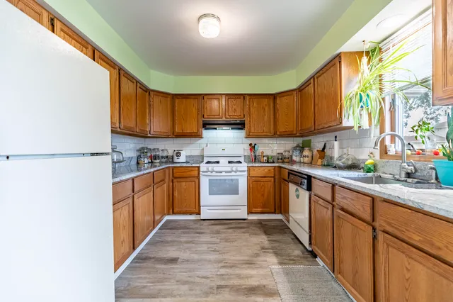 a kitchen with stainless steel appliances granite countertop a stove a sink dishwasher and a refrigerator