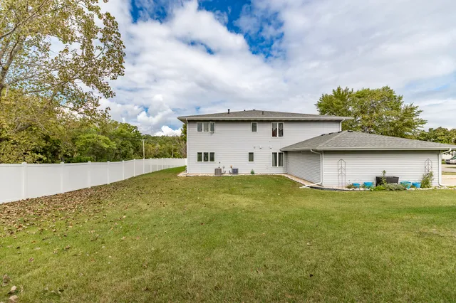 a view of a house with a yard and a large tree