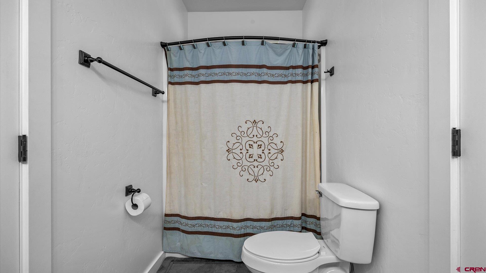 25571 Vail Road Cedaredge, CO 81413 - Photo 21 of 35 a bathroom with a toilet and a shower curtain