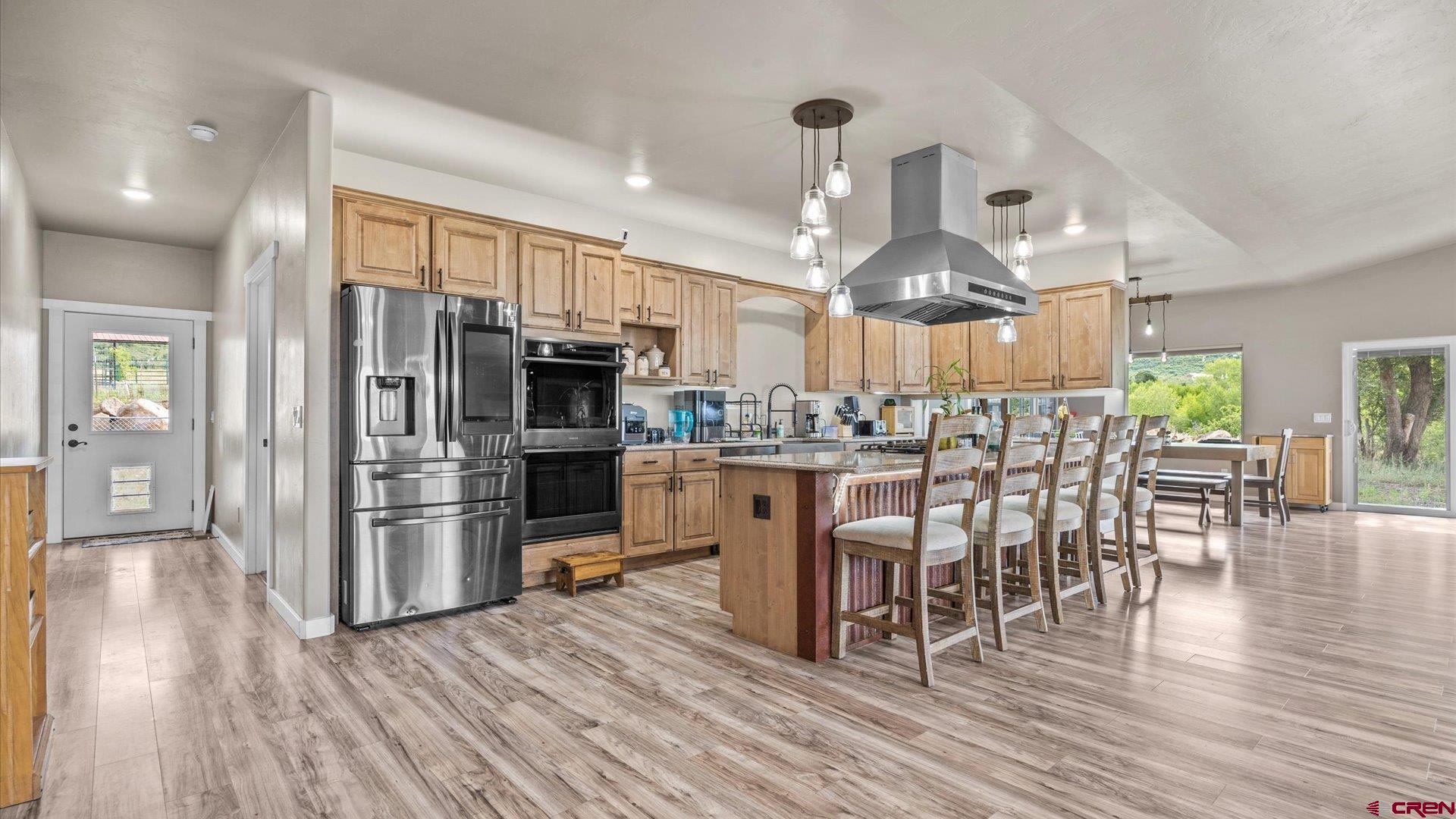 25571 Vail Road Cedaredge, CO 81413 - Photo 8 of 35 a kitchen with stainless steel appliances a dining table chairs stove and refrigerator