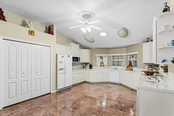 a kitchen with white cabinets and refrigerator