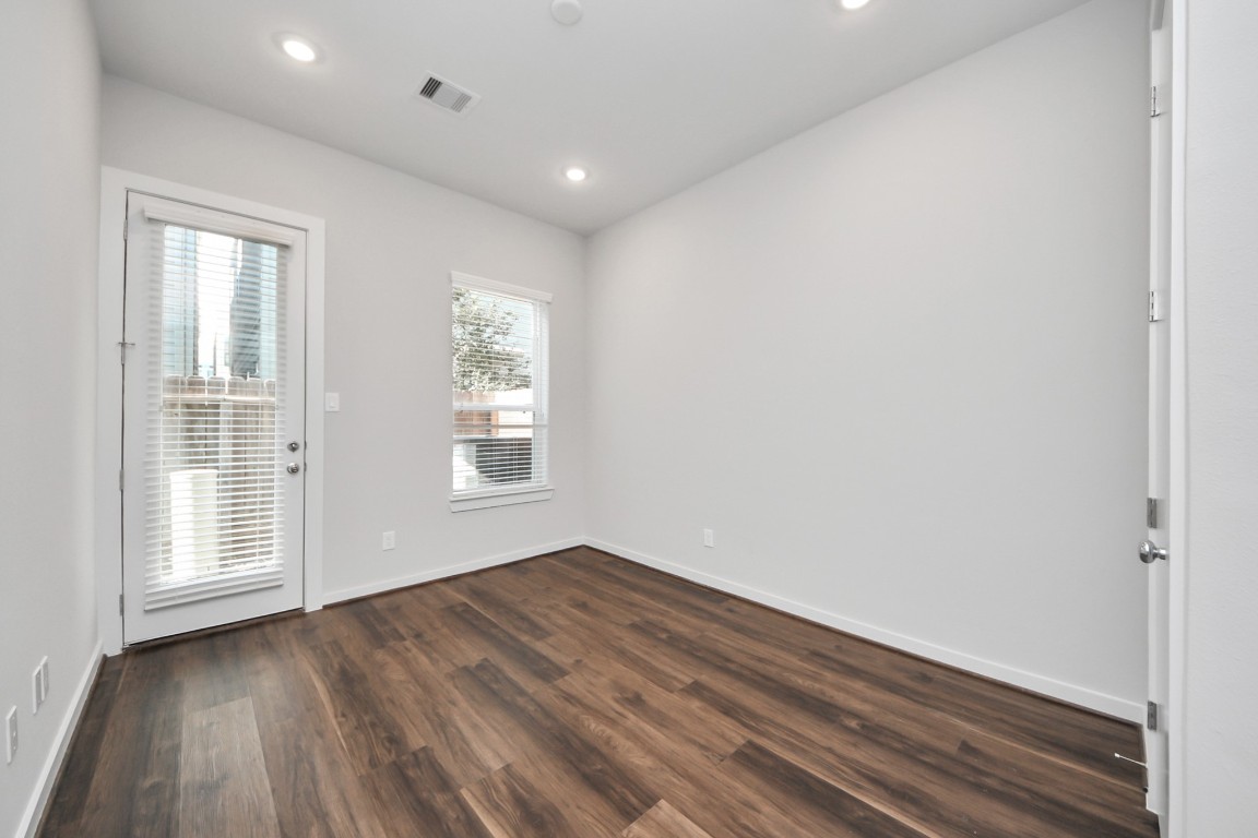 608 Thornton Road, Unit A Houston, TX 77018 - Photo 15 of 44 an empty room with wooden floor and windows