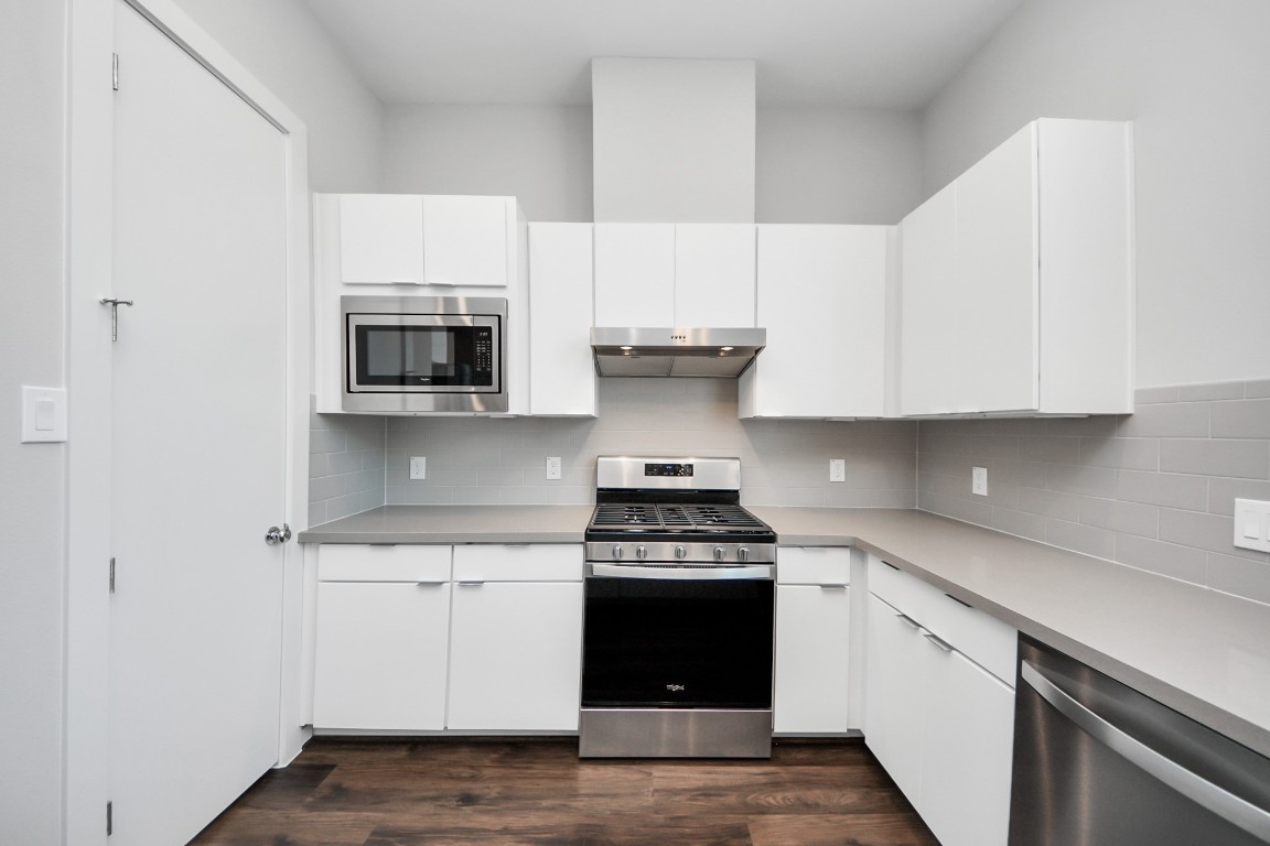 608 Thornton Road, Unit A Houston, TX 77018 - Photo 33 of 44 a kitchen with stainless steel appliances white cabinets and a stove top oven