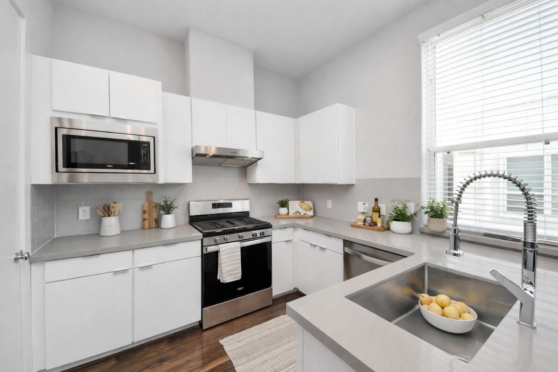 608 Thornton Road, Unit A Houston, TX 77018 - Photo 8 of 44 a kitchen with a sink a stove and wooden cabinets